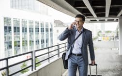 Businessman on business trip telephoning with smartphone